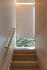 Juno recessed lighting illuminates the ascent to upper-floor private zones.