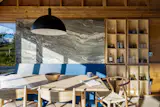 Wishbone chairs surround an ash table. Muskoka Tide marble—named for Ontario's cottage country—backs the built-in banquette.