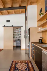 Custom shelving from Modern Shelving organizes provisions for a household that shops infrequently (the nearest major grocery store is 15 miles away).