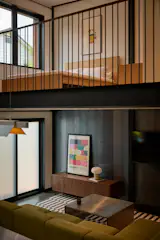 The loft bedroom overlooks the main living area below, taking advantage of luxurious head heights rare in structures this size.