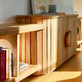 Matching the round motif of the nearby dining table, this custom media console provides record and book storage as well as hides all electronics. 