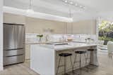 Kitchen, Quartzite Counter, Cooktops, Refrigerator, Dishwasher, Wine Cooler, Ice Maker, Track Lighting, Wood Cabinet, Stone Slab Backsplashe, Undermount Sink, and Accent Lighting  Photo 9 of 20 in The Strawberry 94087 Eichler by Boyenga Team