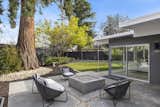 Outdoor, Trees, Side Yard, Walkways, Raised Planters, Large Patio, Porch, Deck, Hardscapes, Shrubs, Wood Fences, Wall, Concrete Patio, Porch, Deck, Vertical Fences, Wall, and Grass  Photo 14 of 20 in The Strawberry 94087 Eichler by Boyenga Team