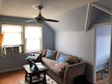 Before: Justin’s room was full of mismatched furniture. A ceiling fan, blue walls, dark floors, and a dividing wall made the space feel dim and weighty.