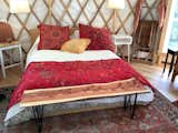 Queen bed with Bangladeshi bedding and live edge bench.
