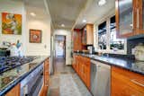 Sleek kitchen design with wall dual oven, tons of beautiful cherry wood cabinets for storage and 33" granite counters.
