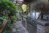 The perfect outdoor entertainment area with built-in gas grill with two burner cook-top, Gabion basket walls, stunning three-waterfall feature and mature gardens.