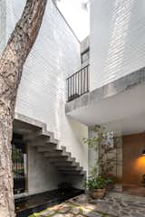 Outdoor, Stone Patio, Porch, Deck, Vertical Fences, Wall, Concrete Patio, Porch, Deck, Trees, Hanging Lighting, Side Yard, Wood Patio, Porch, Deck, and Metal Fences, Wall Main entrance 2  Photo 4 of 17 in R.A House by Estudio Radillo Alba