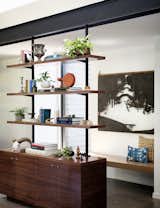 In the main living area, the team built a custom shelving unit made of walnut and steel that’s fitted with brass hardware.