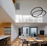 Dining Room, Medium Hardwood Floor, Ceiling Lighting, Pendant Lighting, Chair, and Table Void above Dining space  Photo 3 of 21 in Thanks to a Double-Height Dining Room, a Melbourne Home Basks in Sunshine and Courtyard Views from South Yarra Void House