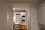 Kitchen, Ceiling Lighting, Dishwasher, Refrigerator, Recessed Lighting, Medium Hardwood Floor, Accent Lighting, White Cabinet, Wall Oven, and Microwave View East to Kitchen  Photo 8 of 23 in Project 555 by Christopher Ransom