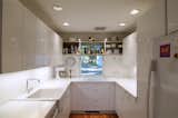Kitchen, Medium Hardwood Floor, Quartzite Counter, Accent Lighting, Ceiling Lighting, Refrigerator, Wall Oven, Dishwasher, White Cabinet, Microwave, and Recessed Lighting Kitchen  Photo 3 of 23 in Project 555 by Christopher Ransom