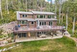 Another view of the back of the home featuring the large, wrap-around deck located on the first floor.  Photo 13 of 16 in An Updated Log Cabin–Style Home in Colorado Seeks $2.4M