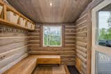 Mudroom offers exposed, shelf storage and stainless steel hooks with picture window overlooking aspen grove.  Photo 16 of 16 in An Updated Log Cabin–Style Home in Colorado Seeks $2.4M