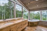 The bathroom located just behind the sleeping space features picture windows that open up views to aspen tree grove.