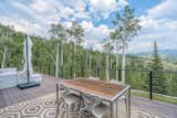 Outdoor, Woodland, Large Patio, Porch, Deck, Back Yard, Decking Patio, Porch, Deck, and Trees View from wrap-around deck on first floor of property.  Photo 15 of 16 in An Updated Log Cabin–Style Home in Colorado Seeks $2.4M