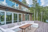 Outdoor, Back Yard, Trees, Large Patio, Porch, Deck, and Decking Patio, Porch, Deck Large wrap-around deck area provides ample room for comfortable, outdoor furniture.  Photo 14 of 16 in An Updated Log Cabin–Style Home in Colorado Seeks $2.4M