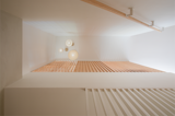 Staircase, Wood Tread, and Wood Railing Stairs and ceiling lights detail. The slots seamlessly extend from the bespoke millwork above, establishing a cohesive visual connection across the entire wall.  Photo 6 of 10 in Bed-Stuy Duplex by STUDIO OCRA