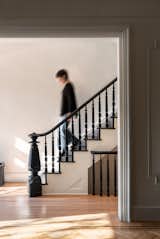The existing staircase was restored and painted to maintain the historical character of the house, while the living room opening was enlarged to create separation, yet continuity between the two spaces.