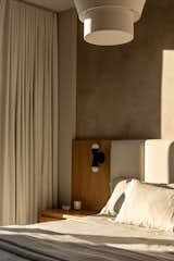 A detail of the bespoke bed with an integrated nightstand and sconces.