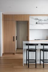 One of the cabinet doors cleverly conceals a passage to the apartment’s service area, here a view of the door open.