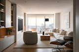 The living room blends built-in millwork with freestanding furniture, all designed with a minimal and neutral palette to evoke a sense of calm and balance.