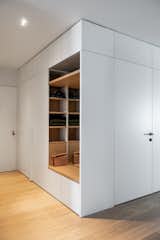 A minimal, cube-like volume was designed in the foyer, integrating storage and wardrobe millwork with a hidden door.