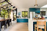 Kitchen, Light Hardwood Floor, Ceramic Tile Backsplashe, Colorful Cabinet, Refrigerator, and Engineered Quartz Counter Benjamin Moore Galapagos Turquoise was selected to balance the black-and-white statement atrium.   Photo 3 of 8 in Colorful Midcentury Revival by Alexandria Abramian