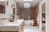 Vroom removed a wall to create a far more spacious primary bathroom. Blush-colored Zia Tile makes a serene statement. 