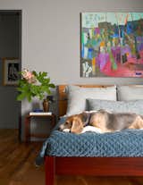 The Bogarts’ beagle, Ranger, lounging on their bed. The painting, All is Well, is an abstract from Brenda’s early days as a painter.