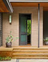 The front porch and entry features two pots from Jackson Pottery planted with cactus.