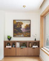 Baker drew unexpected colors from this abstract landscape painting by Matthew Frederick, which hung in the home prior to their remodel. Shades of hunter green and pale lavender harmonize with the range of neutral tones, including the walnut wood from the floating cabinetry.