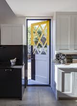 A colorful, geometric Dutch door in the kitchen, designed by artist Roy McMakin.