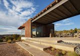 This view between the two casitas shows the compound’s material palette, which includes stone steps, corrugated-metal siding, and steel detailing.