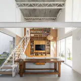 The central library cabinet divides the living room from the master bedroom, extending up to the mezzanine level.