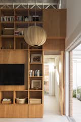 The central cabinet has a multi-functional utility, including library storage in the living room and a doorway into the master bedroom.