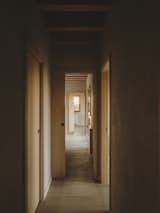 An interior corridor soothes with its neutral walls covered in natural clay.