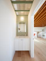 The minty green powder bath is a favorite room of the client's. The clear polycarbonate ceiling adds an element of surprise, while imbuing the pocket-sized space with an indoor-outdoor feel that is connected to the polycarbonate to the sunroom in the ADU.