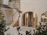 Outdoor, Trees, Back Yard, Shrubs, Concrete Patio, Porch, Deck, Large Patio, Porch, Deck, Small Pools, Tubs, Shower, and Stone Fences, Wall  Photos from In Mallorca, a Once-Crumbling Home Captures the Serenity of the Mediterranean