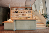 The reception desk, which serves as the threshold to the hotel, features glazed brick and warm red oak shelving.
