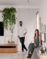 Pedro and Flavia in the light-filled living room, with its long concrete bench which serves as a makeshift bar or seating area.  Photo 3 of 10 in A Major Apartment Renovation in Brazil Hits All the Right Notes