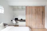 A moving wall offers privacy and a work-station / built in closet for visitors. 