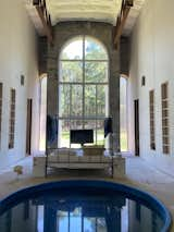 Bedroom, Bed, Shelves, Wall Lighting, Accent Lighting, Concrete Floor, and Bookcase  Photo 5 of 5 in The Water Castle by Julia Vang