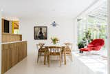 The dining space and sunroom carries classic midcentury pieces. Painting "Girl Reading" by Tim Engelland. Photo by Sarah Shields