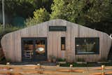 Exterior, Cabin Building Type, Curved RoofLine, Shingles Roof Material, and Wood Siding Material Exterior of Hergest Lee Cabin, cedar cladding and woven cedar fence. The sharpness of the windows gives contrast to the soft curves of the cabin roof.  Photo 4 of 24 in Hergest Lee by Rachael Fisher