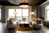 Looking west toward the sunset and into the salon, the Arteriors’ Meadow Cocktail Table centers a pair of Interlude sofas over a 9-foot Safavieh round. In the lounge, the raw sheet metal fireplace surround echoes the gun ship's hull. Above, Beehive Organic Blocks cork the ceilings, below the Phillips Collection Agnes Root Coffee Table anchors the convo.
