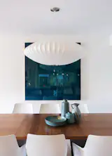 a beautiful Bensen dining table is enhanced by a Nelson Bubble Lamp and a George Vergette painting