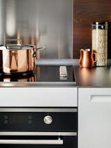 a micro thin chromed, fingerprint resistant stainless steel countertop compliments and contrasts a warm walnut laminate backsplash