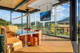 Living room/kitchen; island with built-in banquette and shelving; dropdown TV in case you somehow get tired of the view....