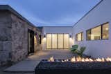 Center courtyard features a steel fire-pit with exposed aggregate piano key floor and steel clad window and door frames in the historic stone facade